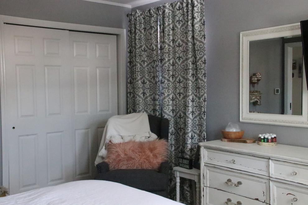 Landhausstil Hauptschlafzimmer mit grauer Wandfarbe, braunem Holzboden und Kaminumrandung aus Holz in Chicago