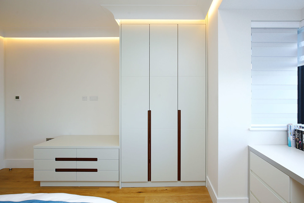 Idee per una grande camera degli ospiti moderna con pareti bianche, parquet chiaro e pavimento marrone
