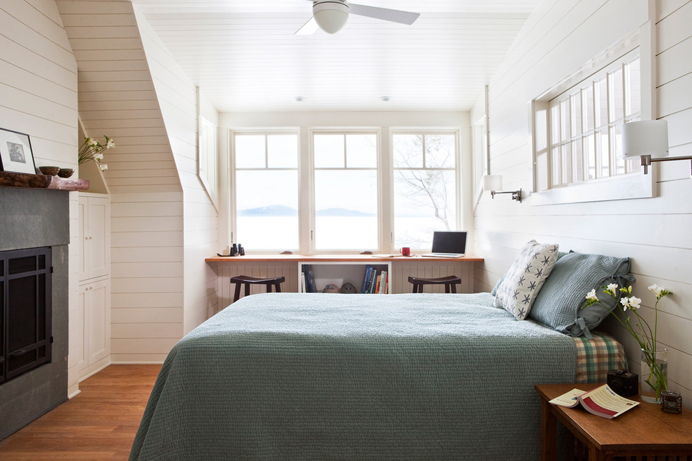 Ejemplo de dormitorio tradicional con paredes blancas, suelo de madera en tonos medios y techo inclinado