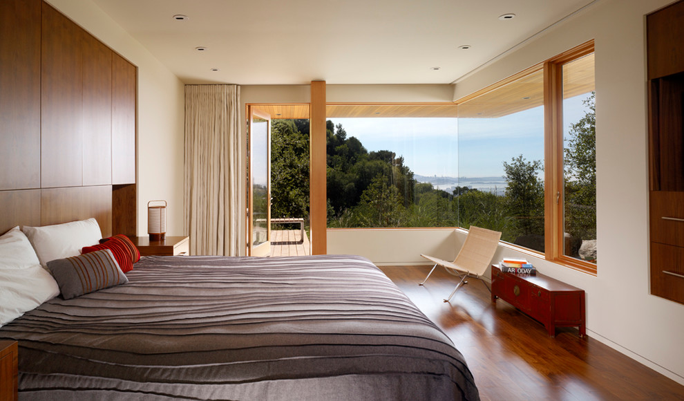 Esempio di una camera da letto design con pareti bianche e pavimento in legno massello medio