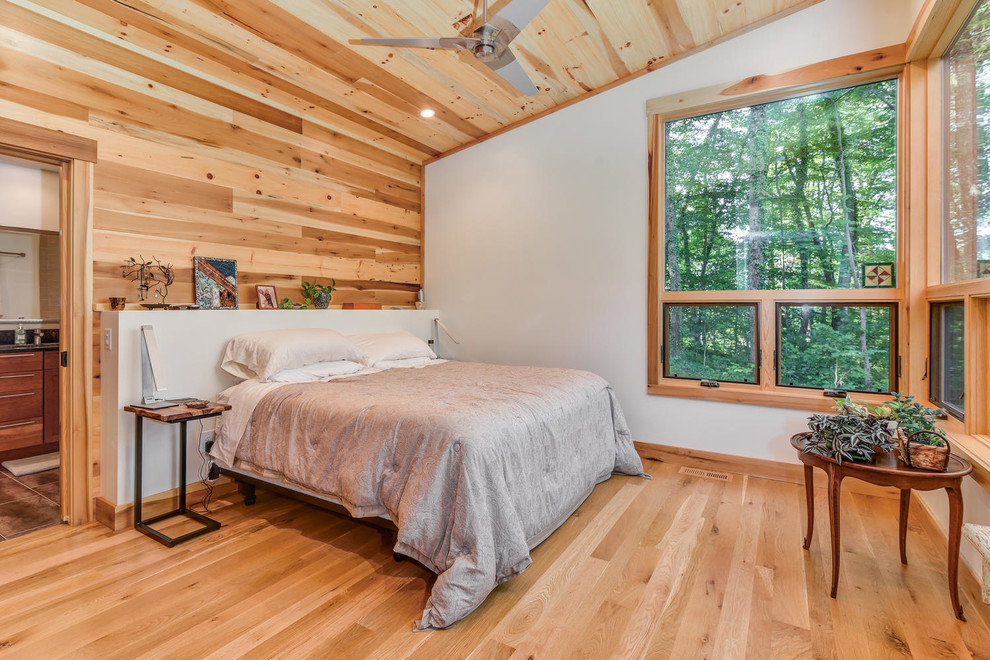 Foto de dormitorio principal rural con paredes blancas y suelo de madera clara
