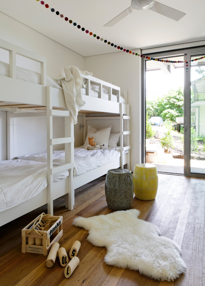 Esempio di una camera degli ospiti minimal di medie dimensioni con pareti bianche, pavimento in legno massello medio e pavimento marrone