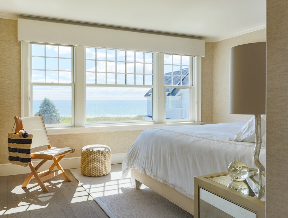Cette photo montre une chambre d'amis bord de mer de taille moyenne avec un mur beige et parquet clair.