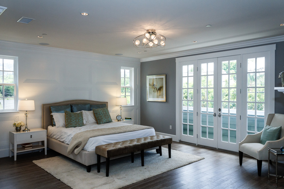 Foto de dormitorio principal actual extra grande con paredes multicolor, suelo de madera en tonos medios y todas las chimeneas