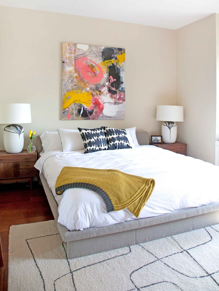 Immagine di una camera da letto design con pareti beige e parquet scuro
