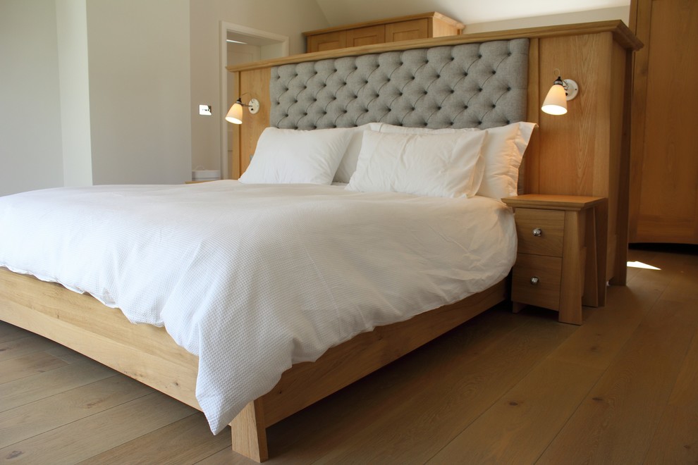 Design ideas for a medium sized contemporary master bedroom in West Midlands with white walls and light hardwood flooring.