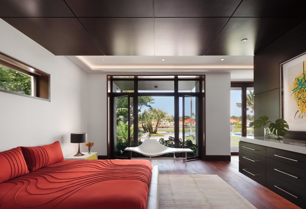 Inspiration for a large contemporary master medium tone wood floor bedroom remodel in Miami with white walls