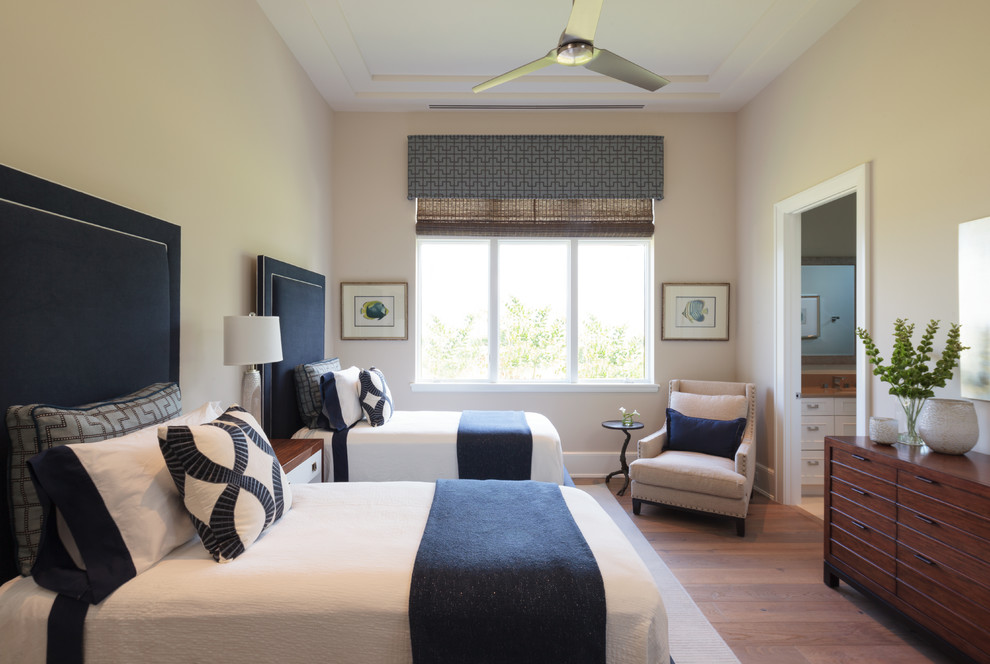 Modelo de habitación de invitados contemporánea grande con paredes beige y suelo de madera clara