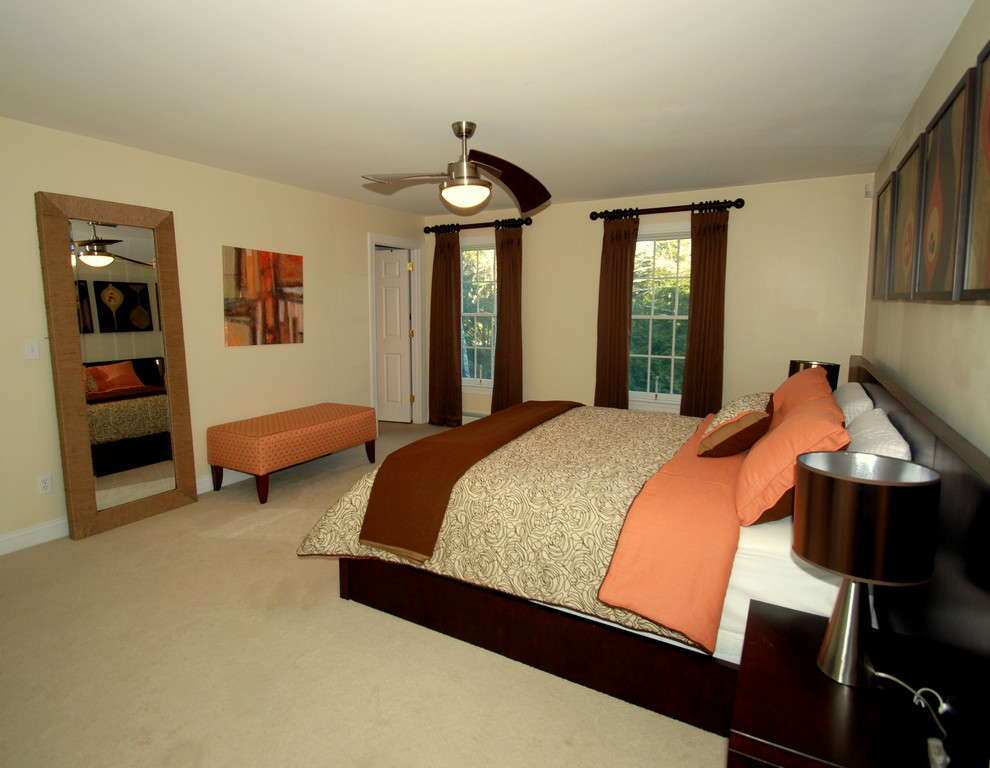 Example of a large trendy master carpeted bedroom design in Manchester with beige walls