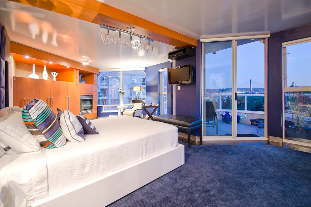 Immagine di una camera matrimoniale design con pareti viola, pavimento blu e TV