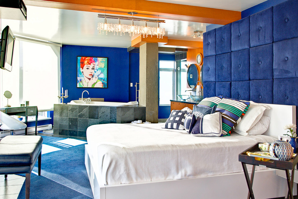 Modelo de dormitorio principal actual sin chimenea con paredes azules y suelo azul