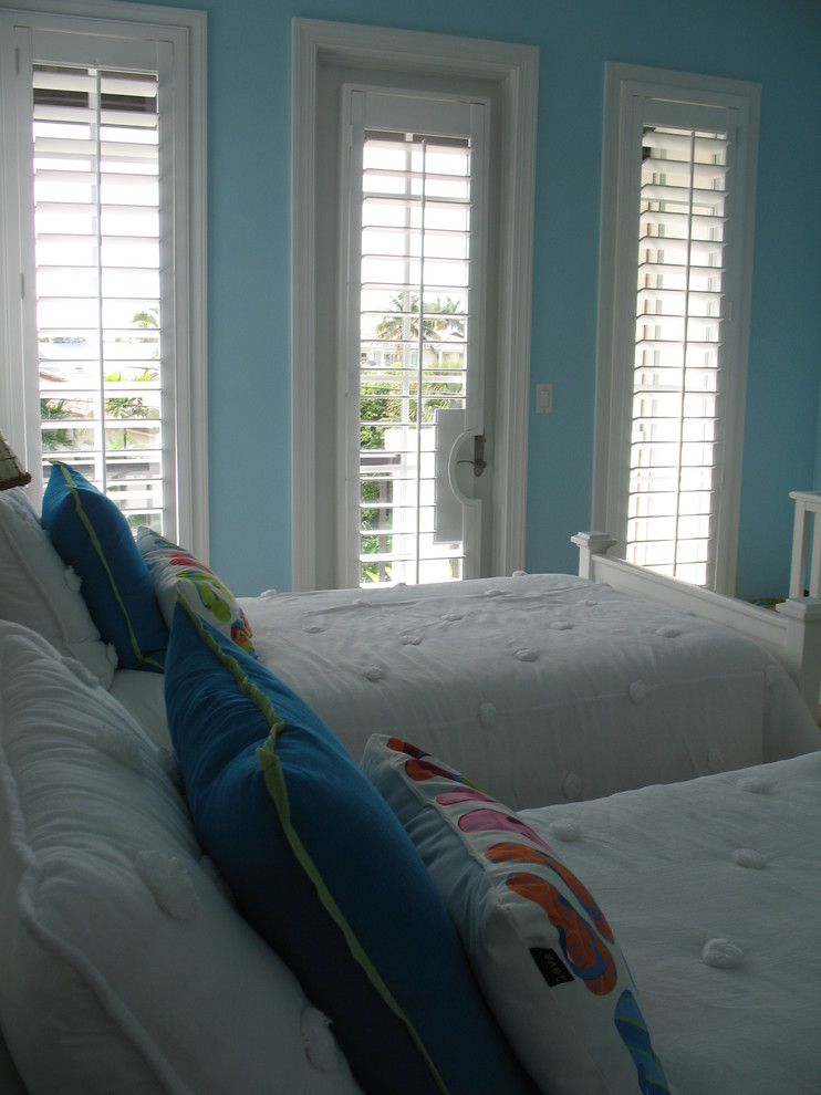 Large beach style guest light wood floor bedroom photo in Miami with blue walls and no fireplace