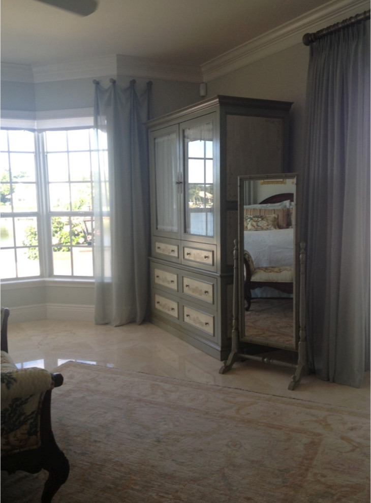 This is an example of a medium sized classic bedroom in Miami with blue walls, travertine flooring and no fireplace.