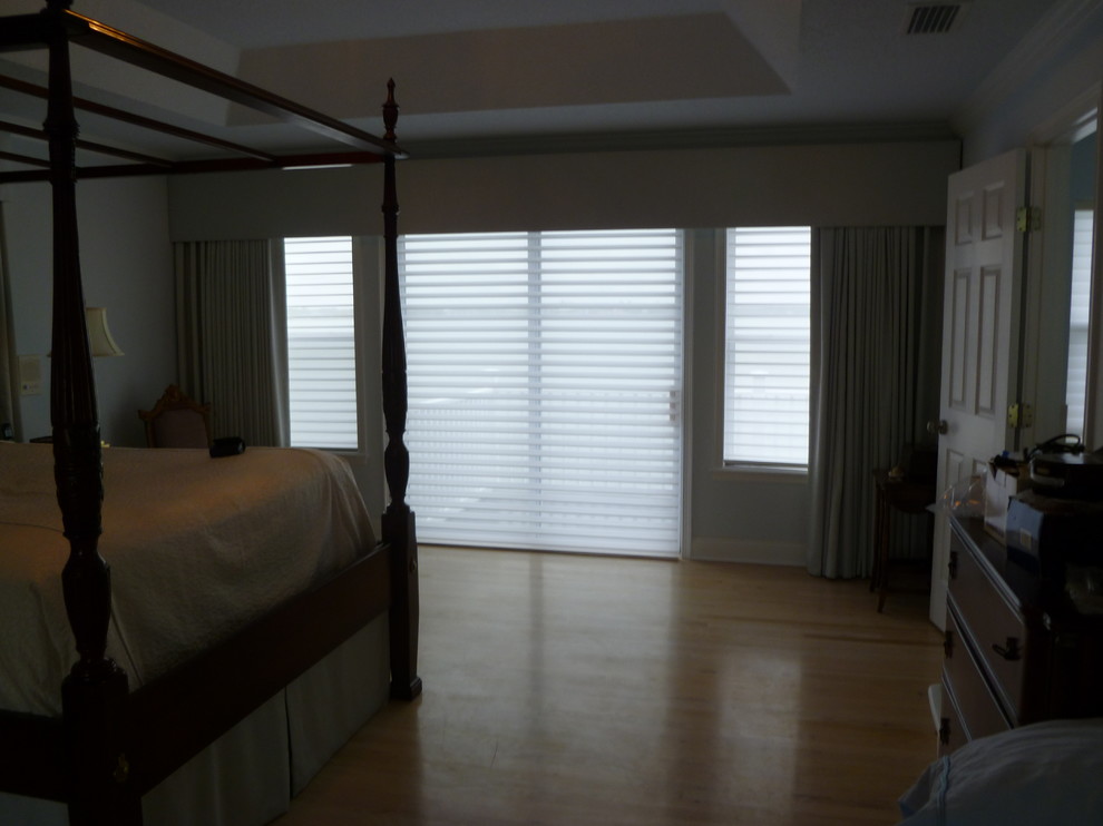 Foto de dormitorio principal tradicional grande sin chimenea con paredes azules y suelo de madera en tonos medios