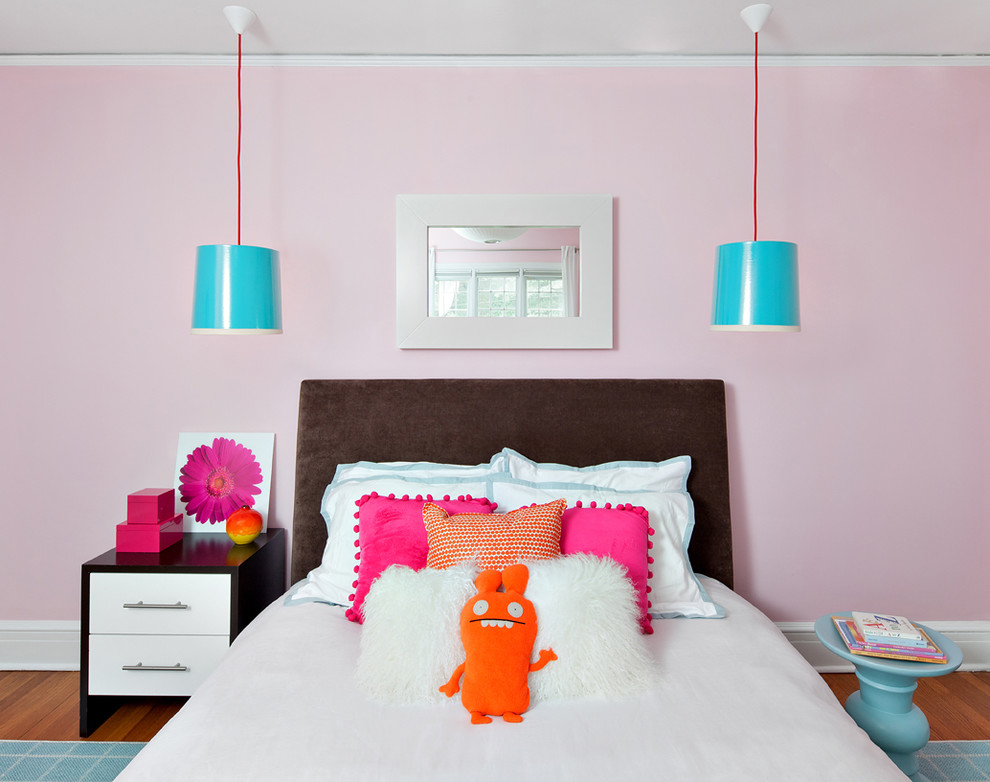 Ejemplo de dormitorio actual con paredes rosas y suelo de madera en tonos medios
