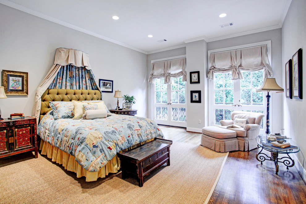 Klassisches Hauptschlafzimmer mit grauer Wandfarbe und braunem Holzboden in Houston