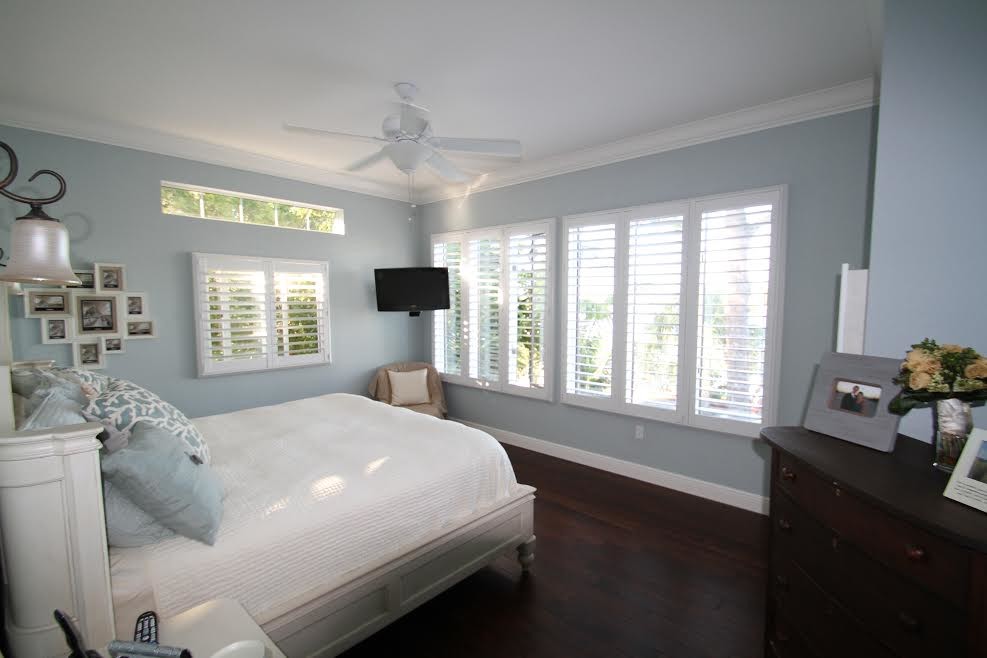 Ejemplo de habitación de invitados tradicional de tamaño medio con paredes azules y suelo de madera oscura