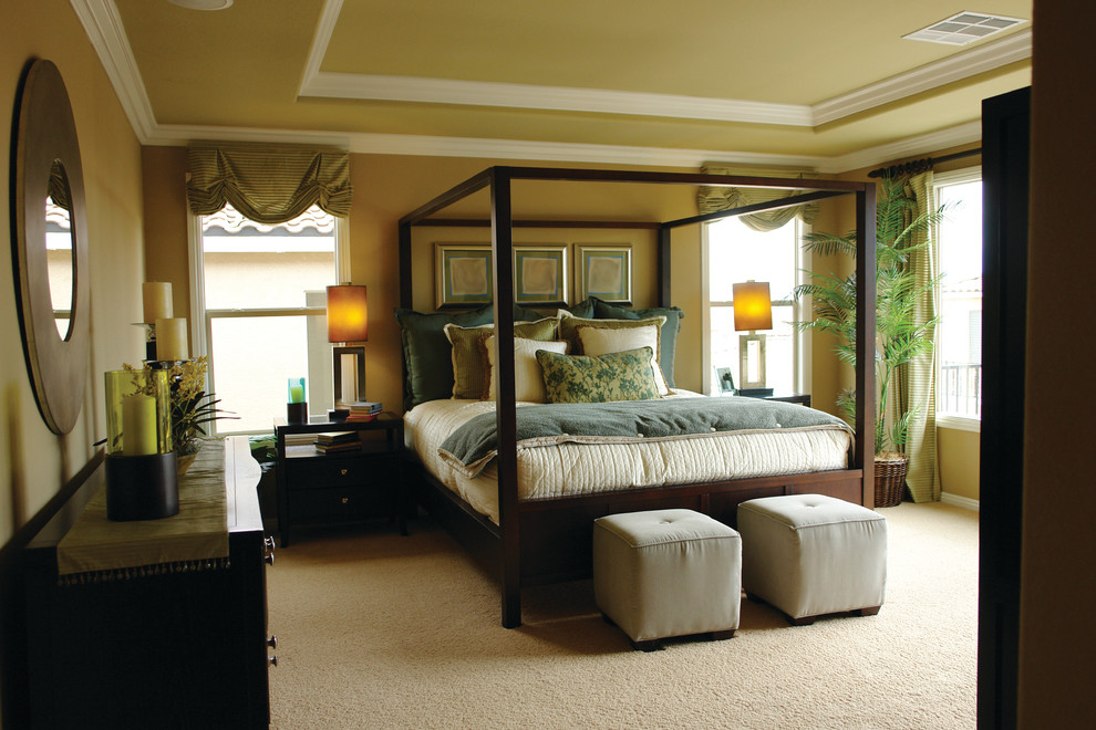 Modelo de dormitorio principal clásico renovado de tamaño medio con paredes amarillas y moqueta