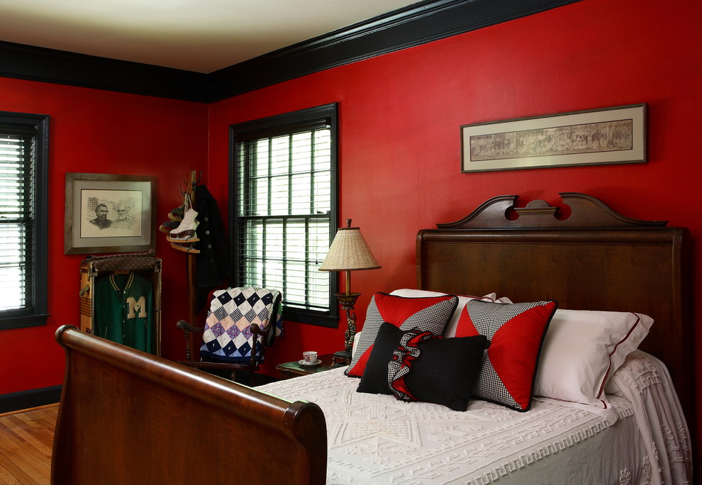 Imagen de habitación de invitados bohemia grande sin chimenea con paredes rojas y suelo de madera en tonos medios