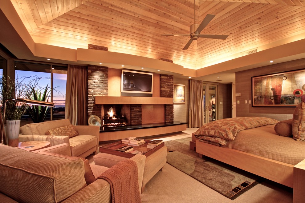 Cette photo montre une grande chambre tendance avec un mur marron, une cheminée standard et un manteau de cheminée en brique.