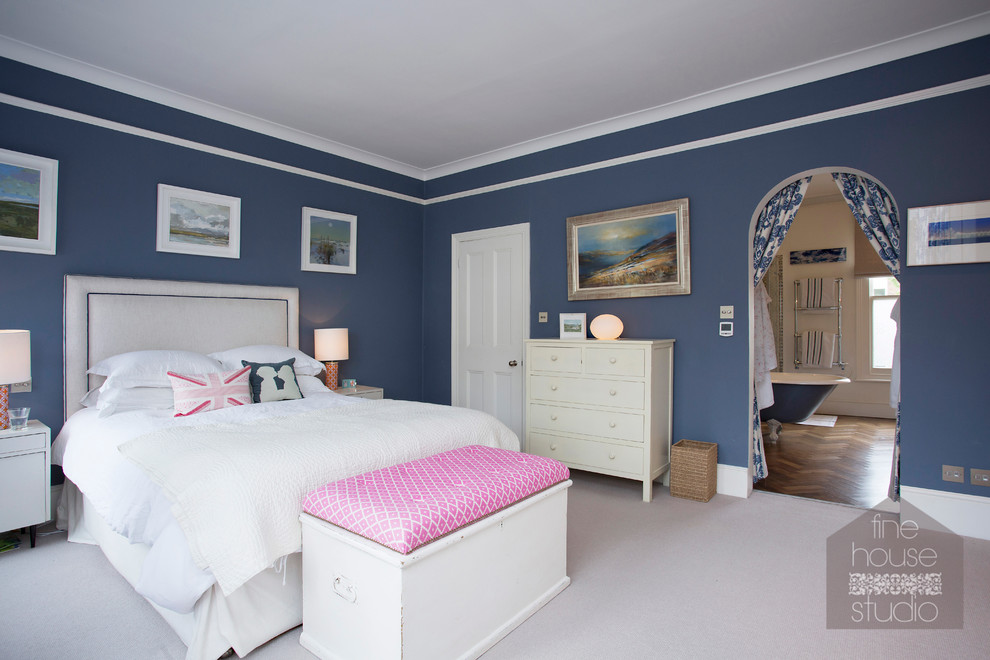 Photo of a large bohemian master bedroom in Gloucestershire with blue walls and carpet.