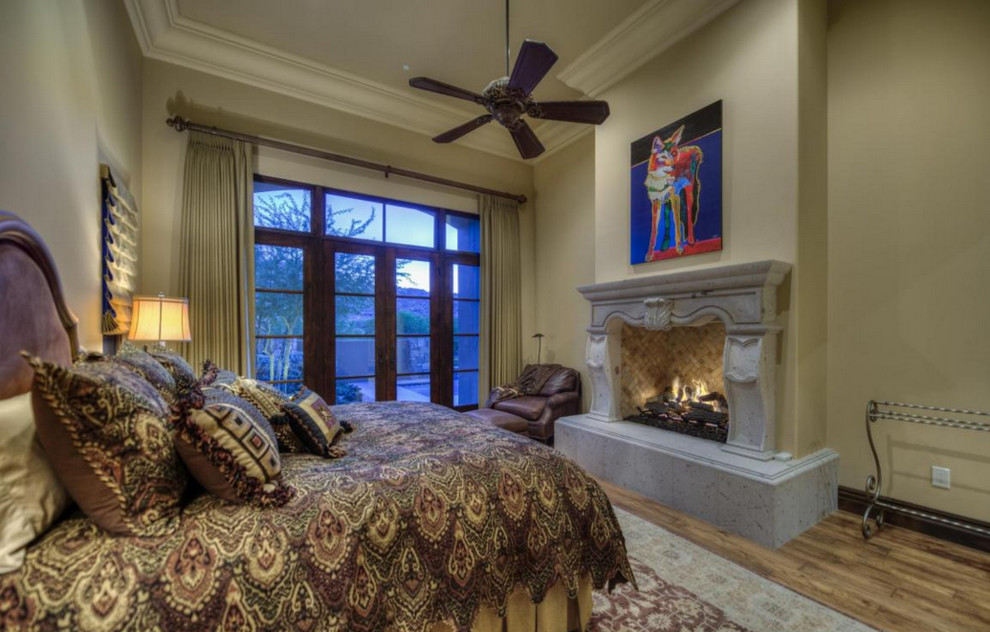 フェニックスにある巨大なおしゃれな主寝室 (ベージュの壁、カーペット敷き、暖炉なし、石材の暖炉まわり)