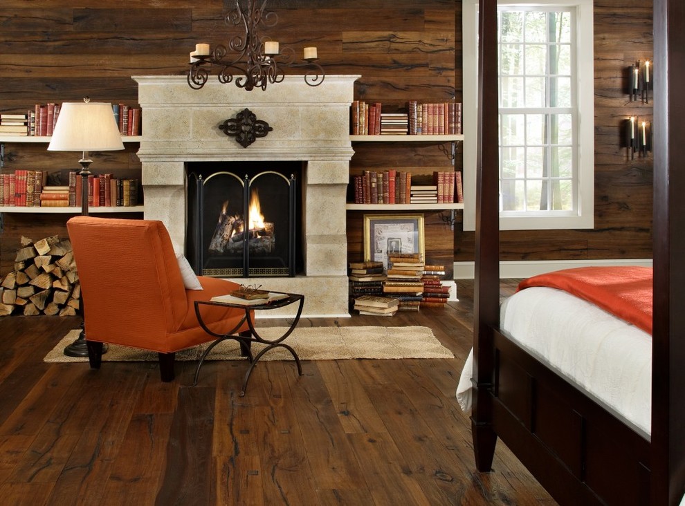 Large rustic master bedroom in Other with brown walls, dark hardwood flooring, a standard fireplace and a stone fireplace surround.