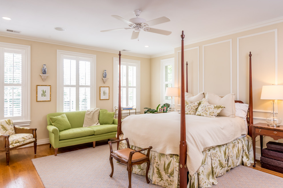 Klassisches Schlafzimmer mit beiger Wandfarbe und braunem Holzboden in Sonstige