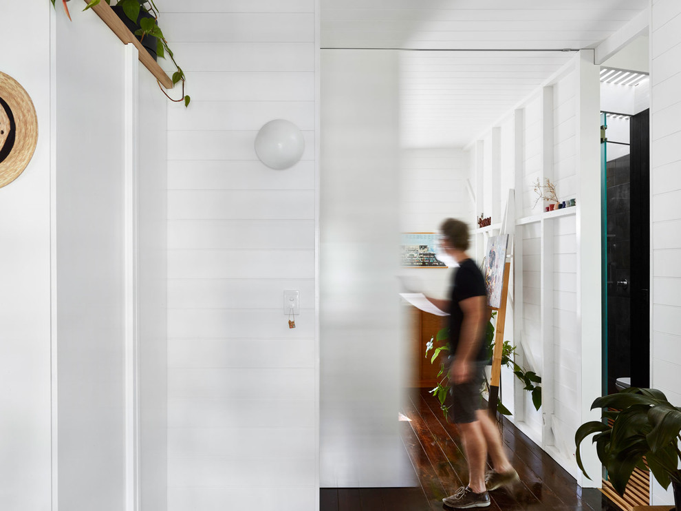 Idee per una camera degli ospiti moderna di medie dimensioni con pareti bianche, parquet scuro e pavimento nero