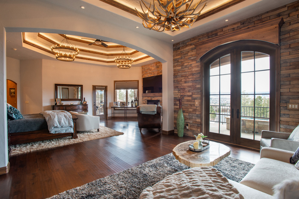 Inspiration for a huge rustic master bedroom remodel in Denver with a standard fireplace and a brick fireplace