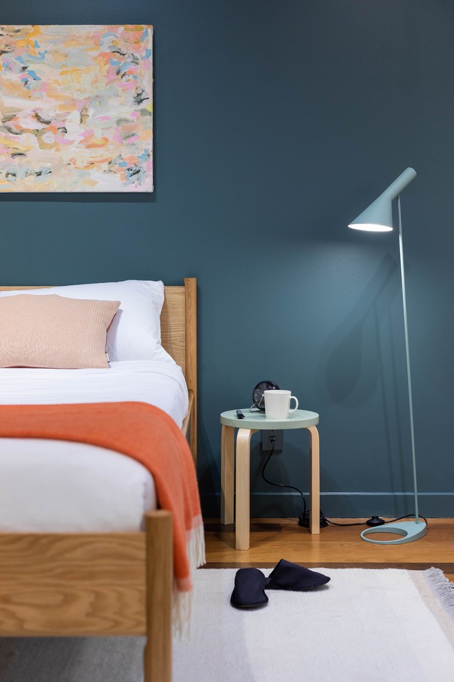 Modelo de dormitorio actual con paredes azules y suelo de madera clara