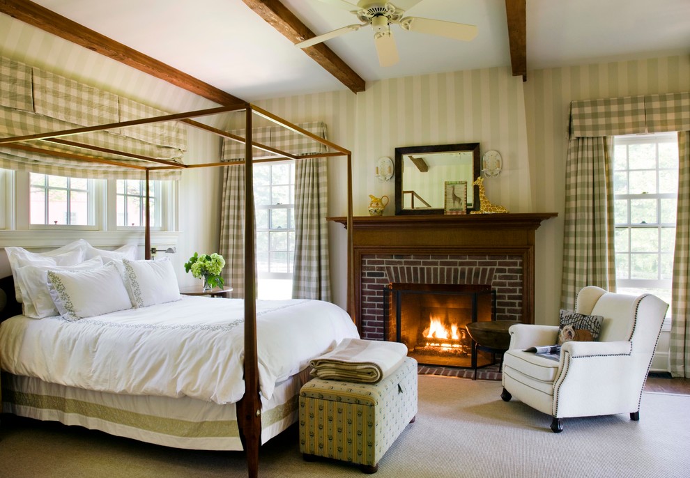 На фото: хозяйская спальня среднего размера в классическом стиле с бежевыми стенами, ковровым покрытием, стандартным камином и фасадом камина из кирпича