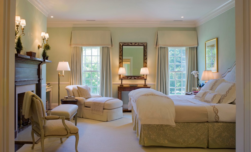 На фото: гостевая спальня среднего размера, (комната для гостей) в классическом стиле с зелеными стенами, ковровым покрытием, стандартным камином и фасадом камина из дерева