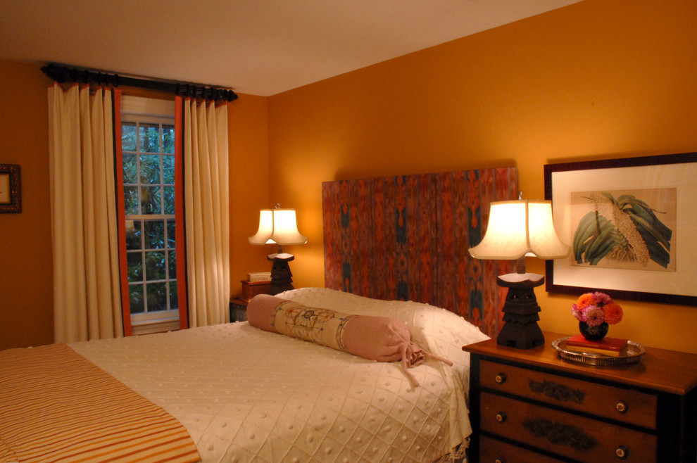 Esempio di una camera da letto con pareti arancioni