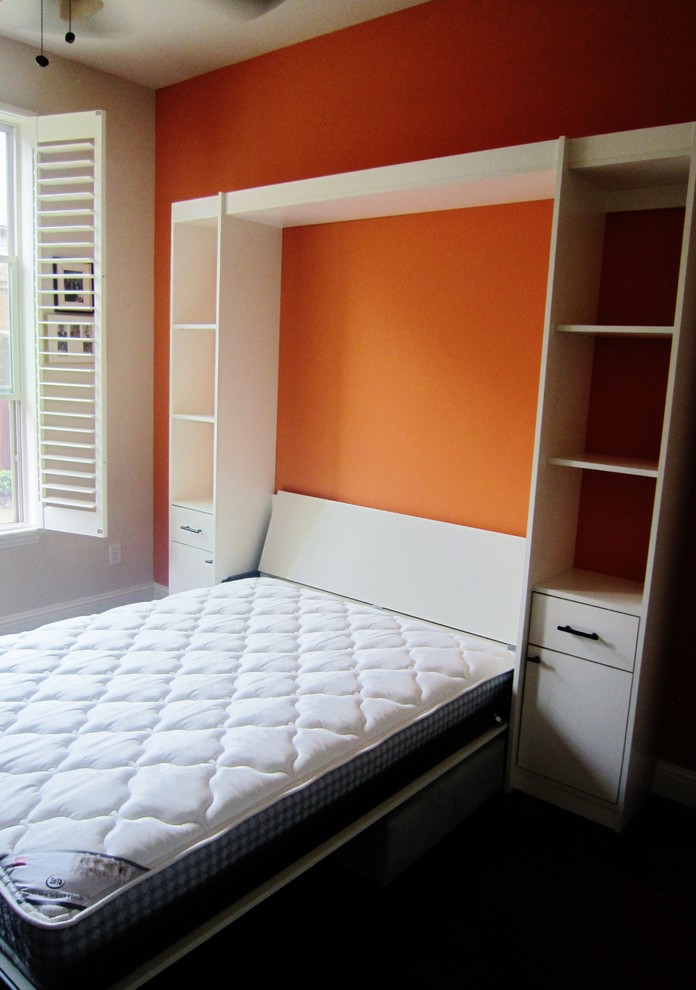 Modelo de habitación de invitados actual pequeña con parades naranjas y suelo de madera oscura