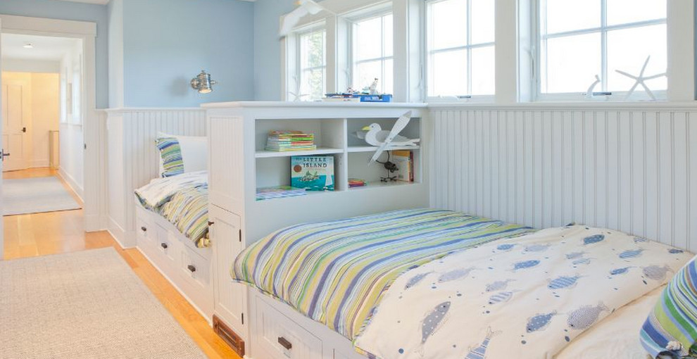 Ejemplo de habitación de invitados costera de tamaño medio sin chimenea con paredes azules y suelo de madera clara