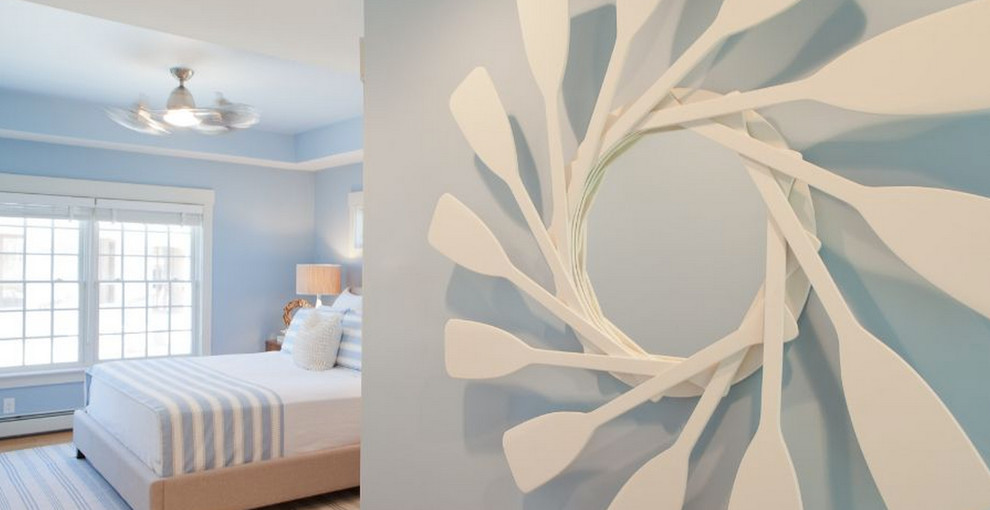 Imagen de habitación de invitados costera de tamaño medio sin chimenea con paredes azules y suelo de madera clara