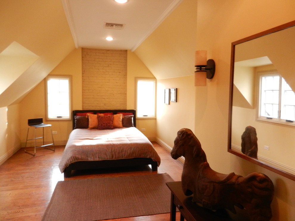 Imagen de dormitorio tipo loft contemporáneo de tamaño medio con paredes amarillas y suelo de madera en tonos medios