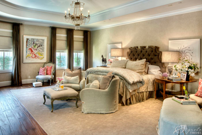 Large bohemian master bedroom in Houston with beige walls and medium hardwood flooring.
