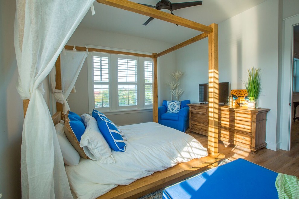 Foto de habitación de invitados costera de tamaño medio sin chimenea con paredes grises y suelo de madera clara