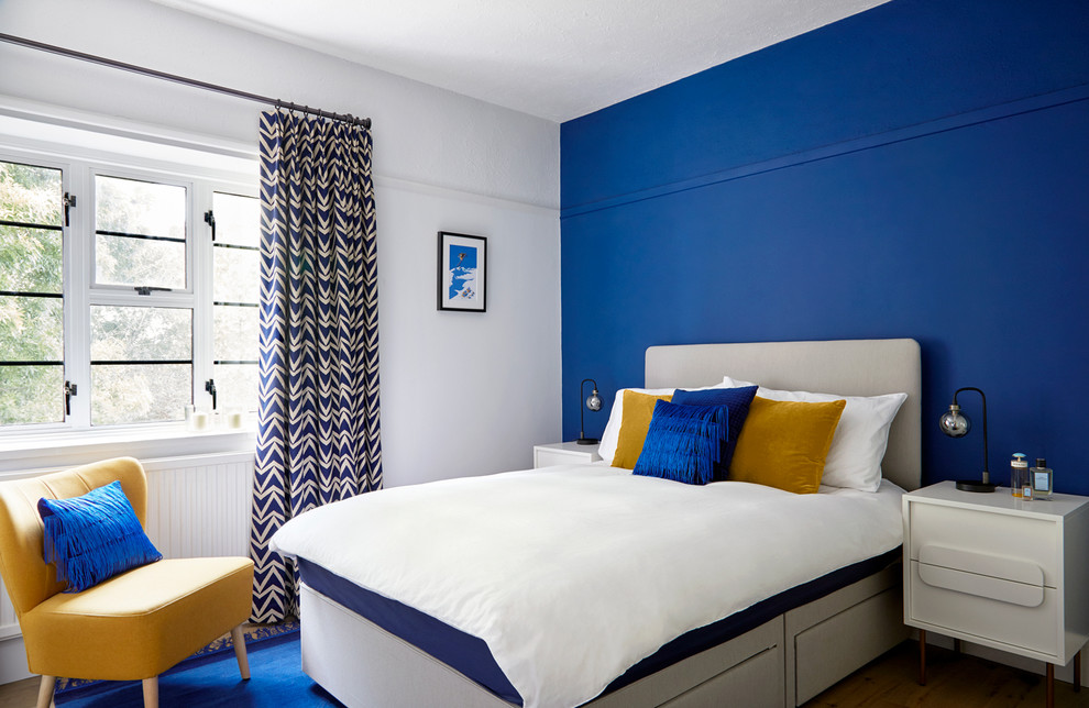 Idéer för ett modernt sovrum, med blå väggar och mörkt trägolv