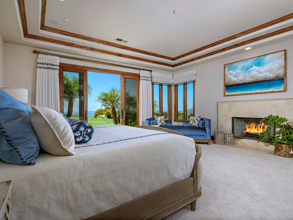 Großes Maritimes Hauptschlafzimmer mit beiger Wandfarbe, Teppichboden, Kamin, gefliester Kaminumrandung und beigem Boden in San Diego