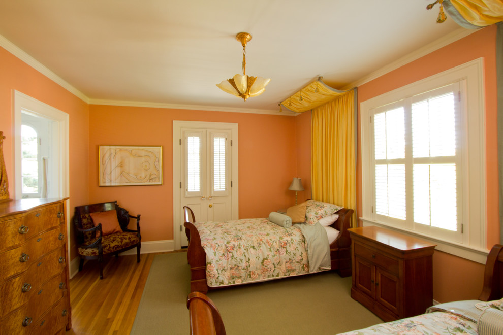 ポートランドにあるトラディショナルスタイルのおしゃれな客用寝室 (オレンジの壁、淡色無垢フローリング、暖炉なし)