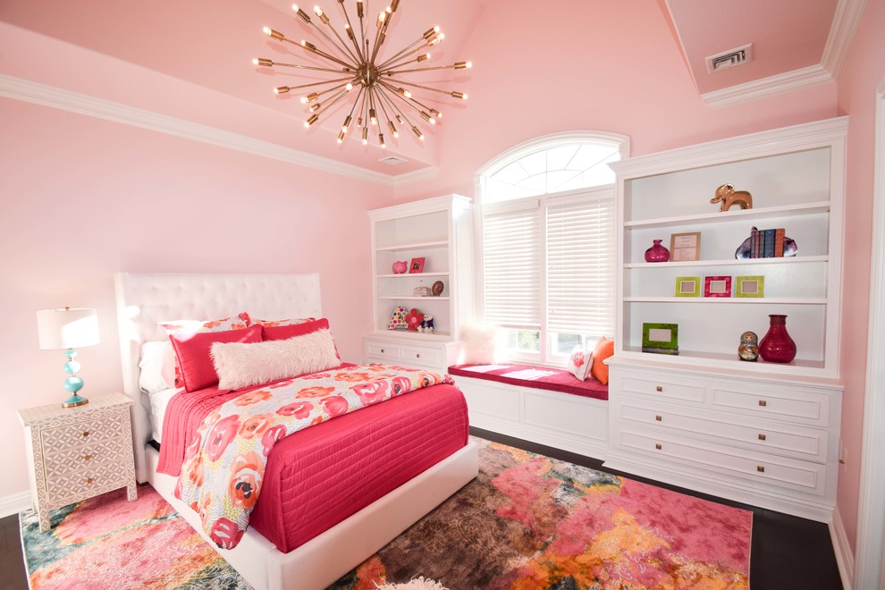 Diseño de dormitorio de tamaño medio con paredes rosas y suelo de madera oscura