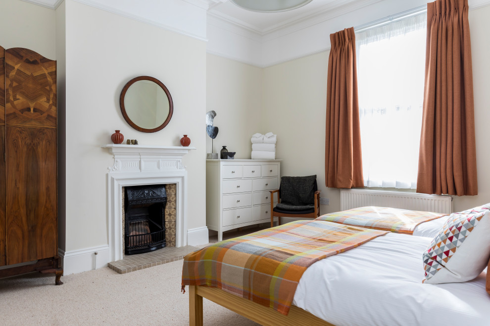 This is an example of a classic bedroom in London with beige walls, carpet, a standard fireplace, a tiled fireplace surround, beige floors and a chimney breast.
