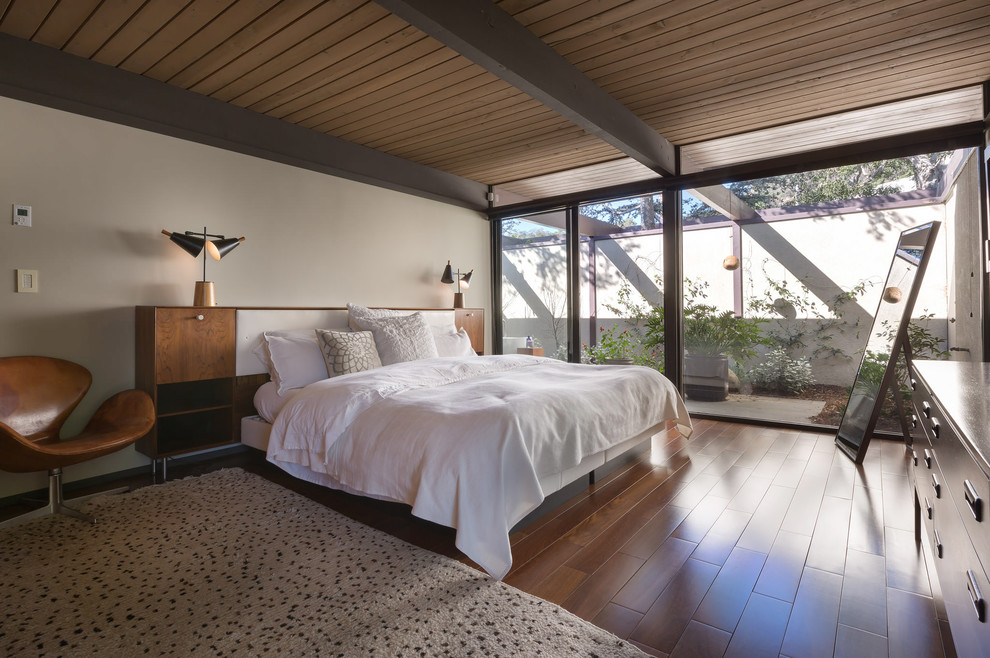 Пример оригинального дизайна: большая хозяйская спальня в стиле ретро с белыми стенами, темным паркетным полом и коричневым полом