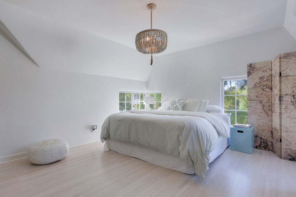 Idée de décoration pour une chambre parentale design de taille moyenne avec un mur blanc et parquet clair.
