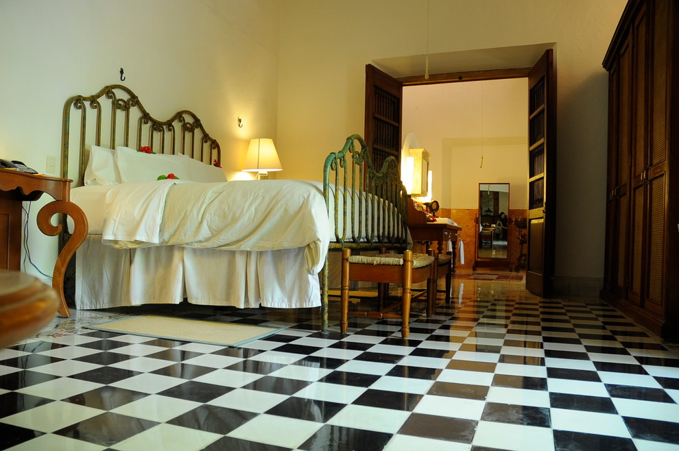 Modelo de dormitorio principal mediterráneo grande con paredes blancas y suelo de cemento