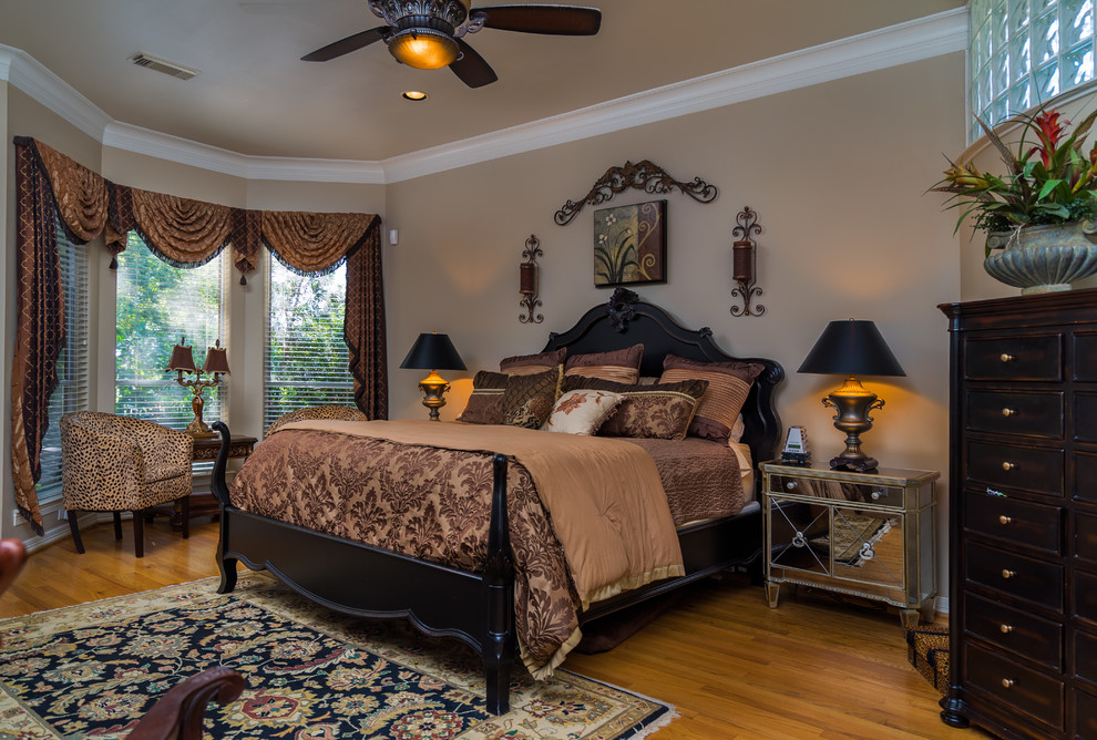 Modelo de dormitorio principal clásico con paredes beige y suelo de madera en tonos medios
