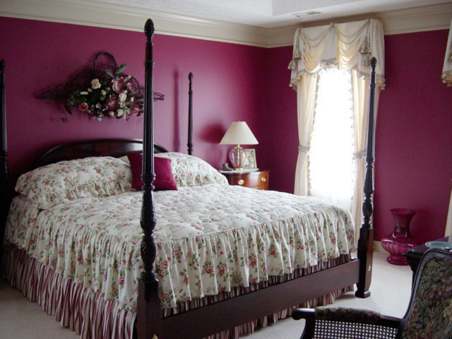 Immagine di una grande camera matrimoniale tradizionale con pareti viola e moquette